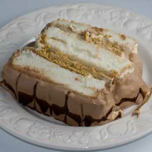 Chocolate whipped cream on a mocha mousse filled angel food cake loaf.