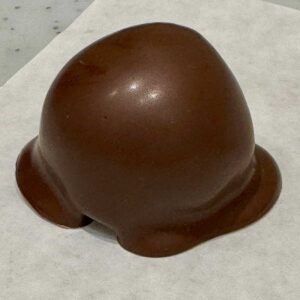 Oreo Truffle draped in chocolate on parchment paper.