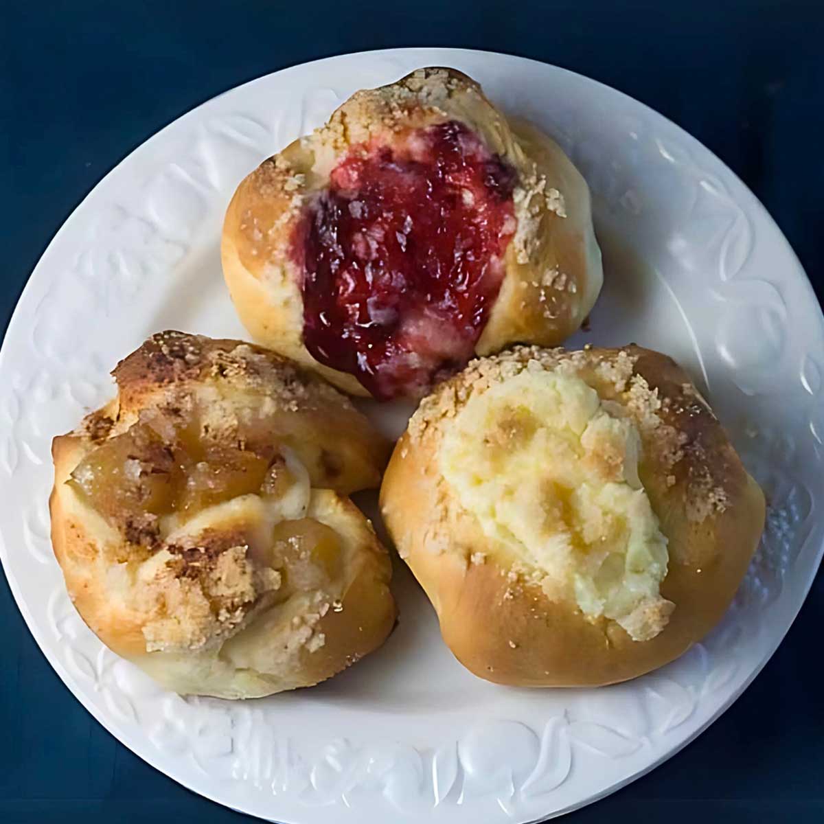 Kolaches filled with apple, jelly and cream cheese fillings.