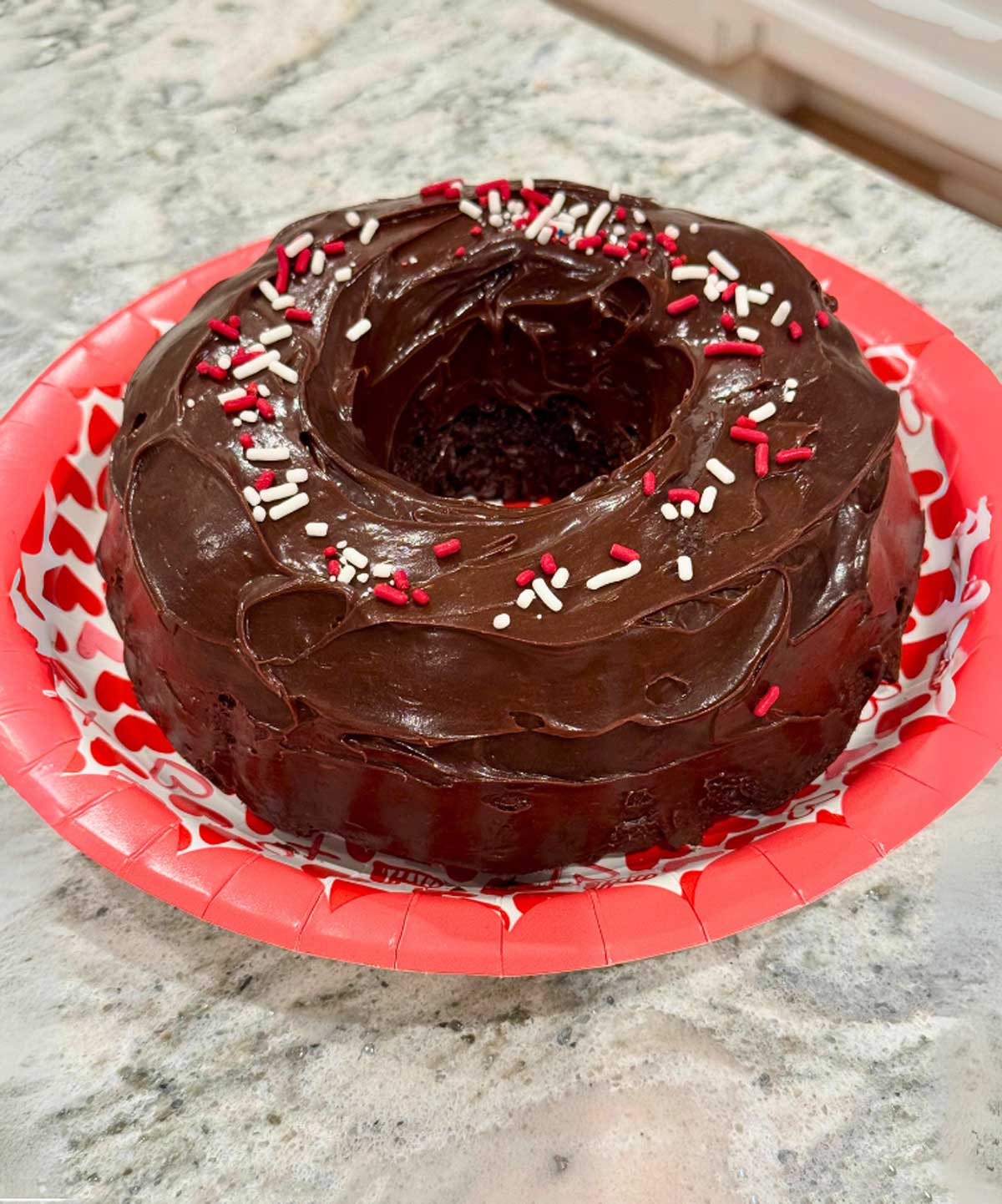 Small chocolate Bundt cake baked in a 6 cup capacity Bundt pan and topped with frosting for Valentine's Day.