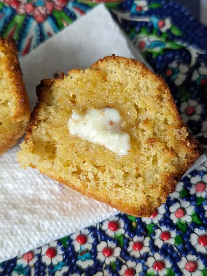 Split Pineapple Cornbread Muffin with butter on it.