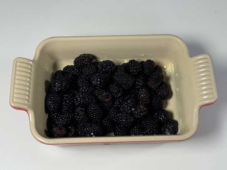 fresh blackberries in a casserole dish for shiny top blackberry cobbler