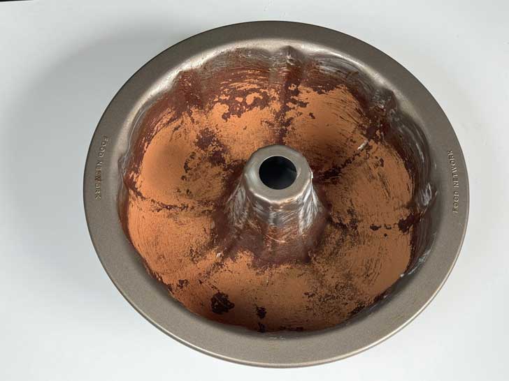 A Bundt pan greased and dusted with cocoa powder for Coconut Ring Cake.