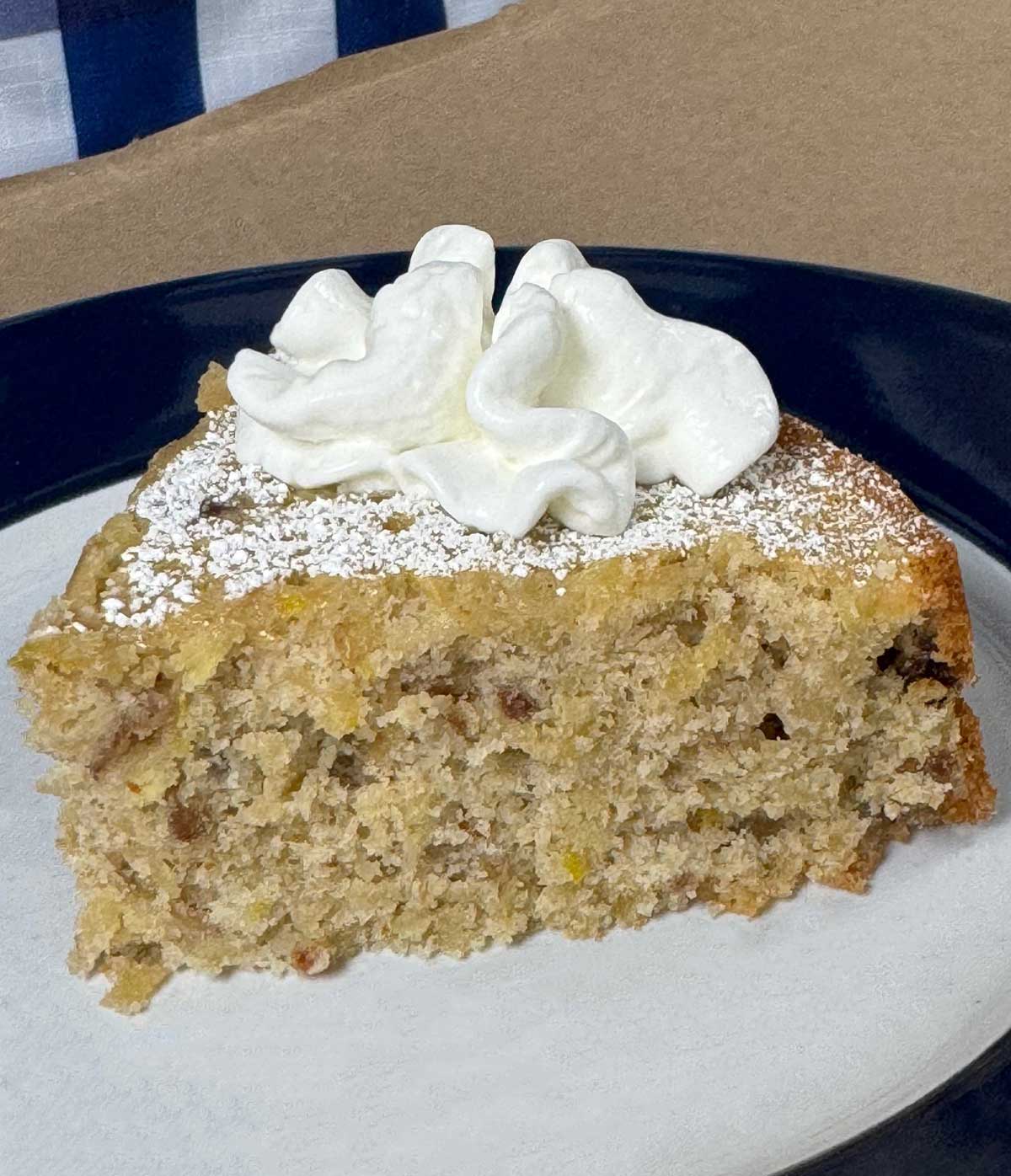 Slice of buckwheat apple olive oil cake on a plate.