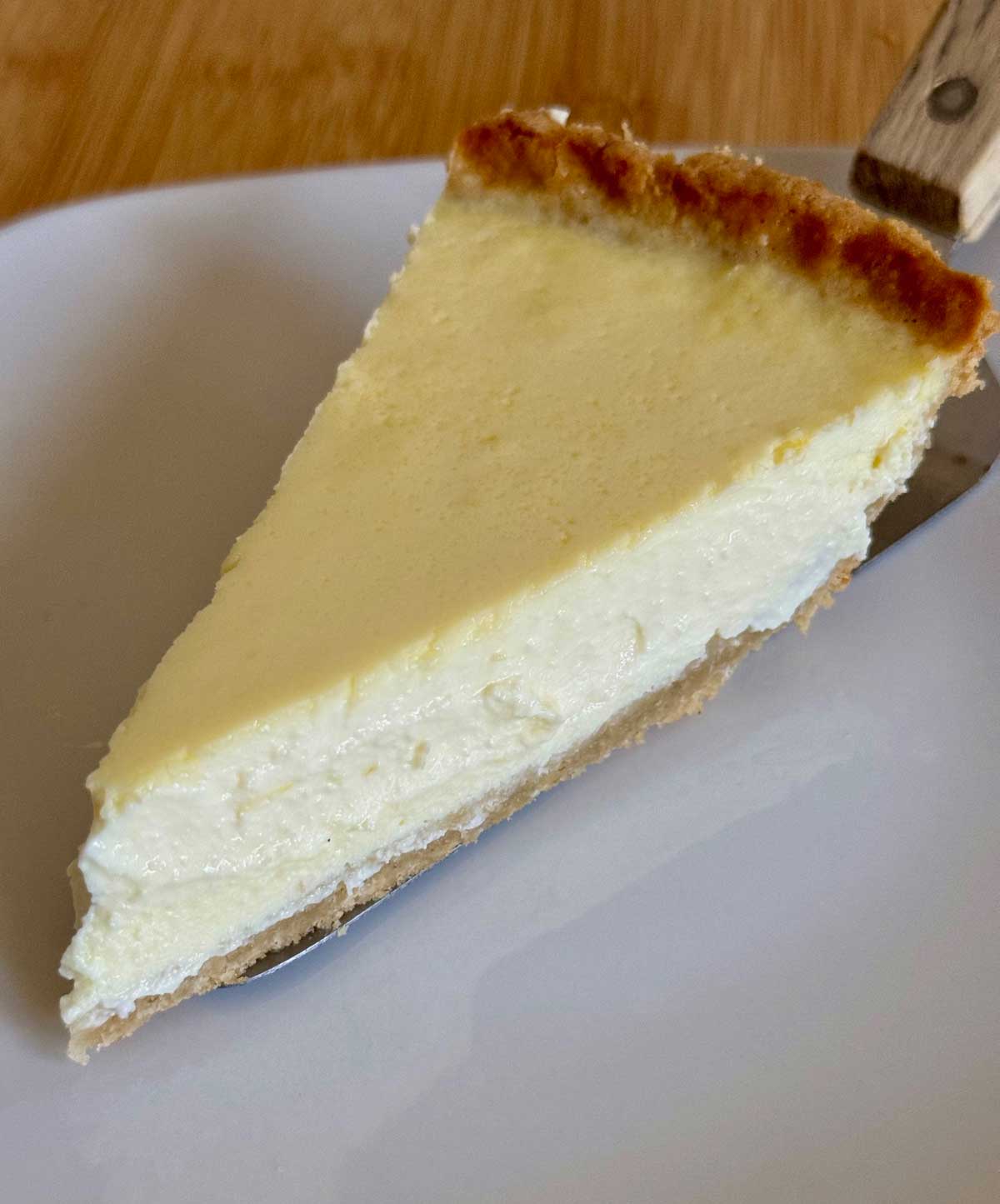 A slice of Ricotta Sour Cream Pie with a gluten-free crust.