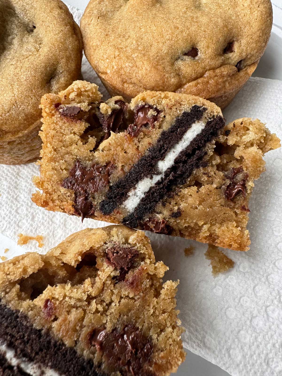 An oreo baked into chocolate chip cookie dough to make Oreo Stuffed Chocolate Chip Cookies muffin shaped.