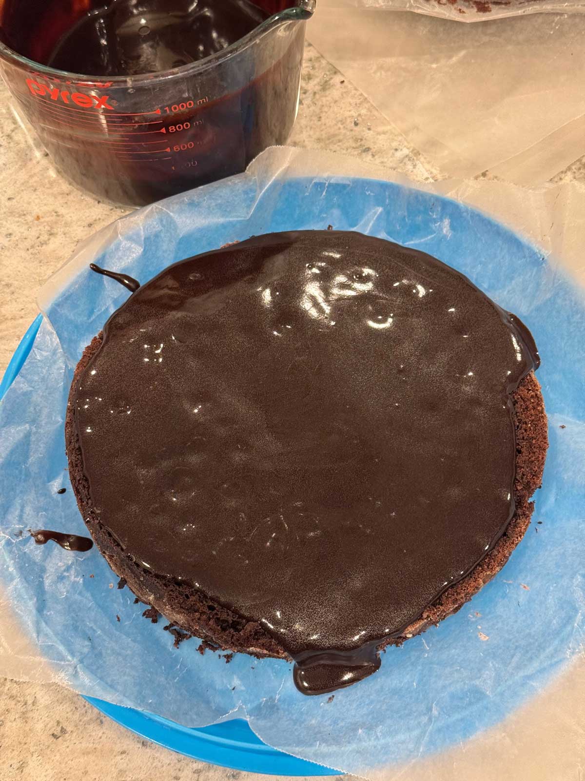 Assembling a three layer chocolate cake filling with pudding.